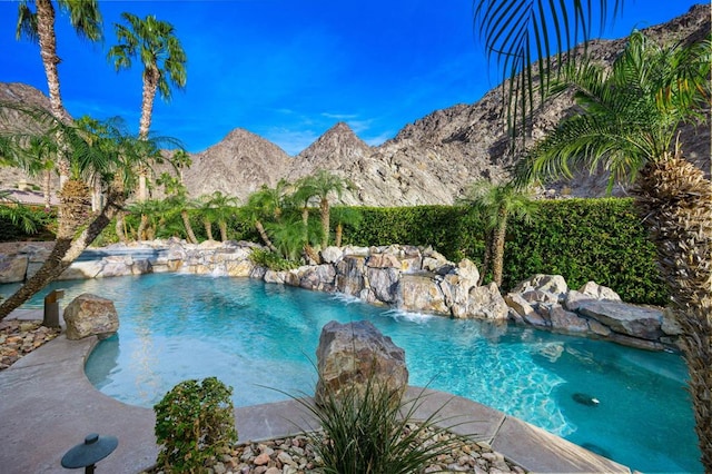 view of swimming pool with pool water feature and a mountain view