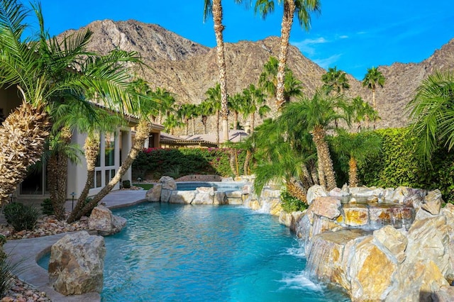 view of swimming pool with a mountain view and pool water feature