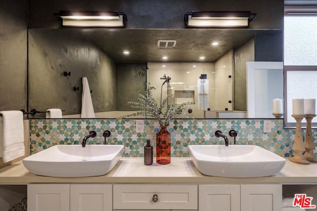 bathroom with decorative backsplash, an enclosed shower, and vanity