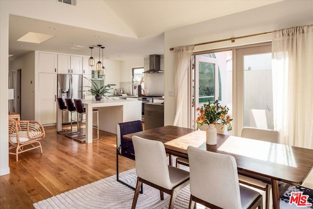 dining area featuring vaulted ceiling and dark wood-type flooring