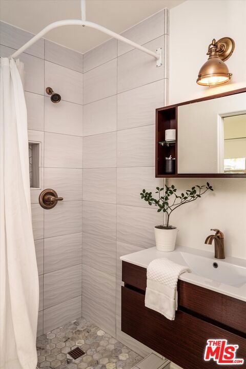 bathroom featuring a shower with shower curtain and vanity