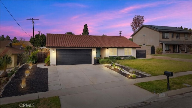 view of front of home featuring a garage and a lawn