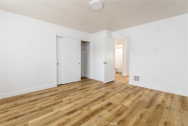 unfurnished bedroom featuring a closet and light wood-type flooring