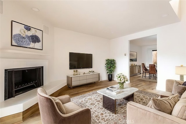 750 Chorro St Unit 5, San Luis Obispo, CA 93401 - living room with wood finished floors, a fireplace with raised hearth, and baseboards