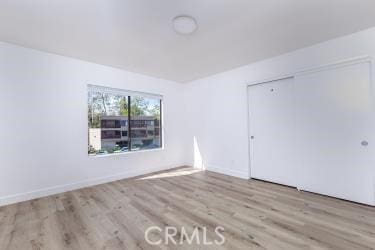 750 Chorro St Unit 5, San Luis Obispo, CA 93401 - unfurnished bedroom featuring wood finished floors, a closet, and baseboards