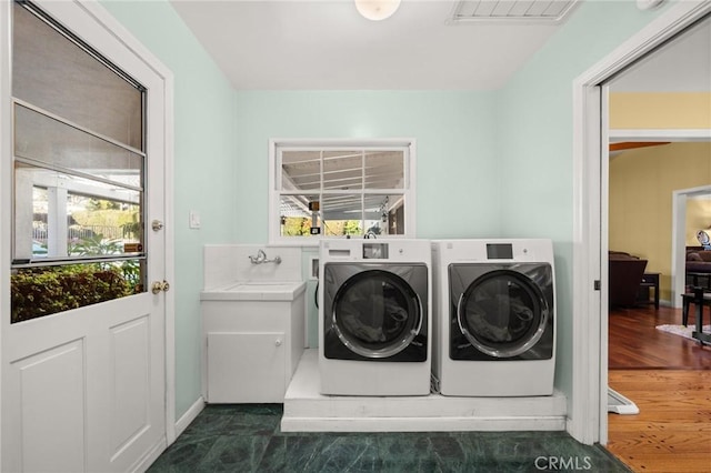 clothes washing area featuring washing machine and dryer and sink