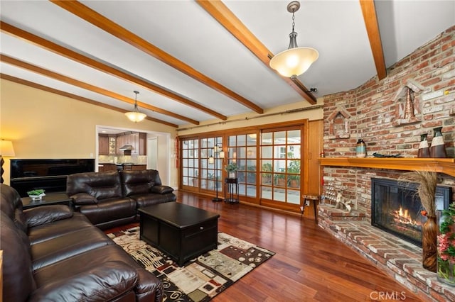 living room with dark hardwood / wood-style flooring, lofted ceiling with beams, and a fireplace