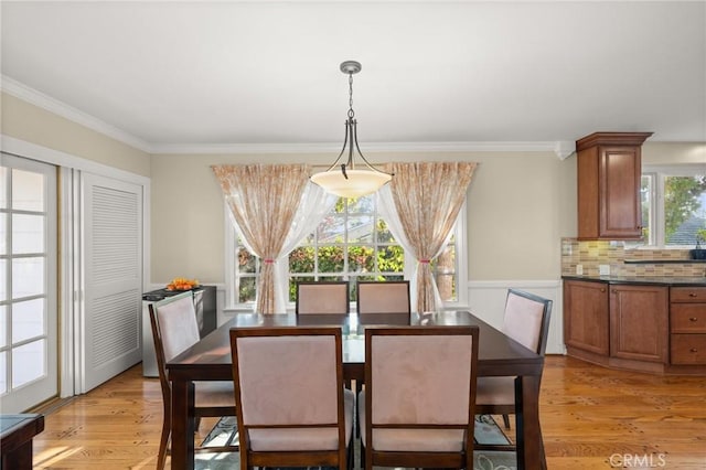 dining area with light hardwood / wood-style floors and crown molding