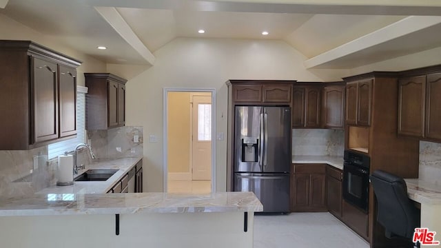 kitchen featuring lofted ceiling, sink, oven, kitchen peninsula, and stainless steel refrigerator with ice dispenser