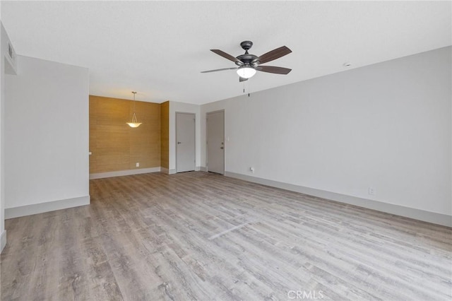 empty room with ceiling fan and light hardwood / wood-style floors