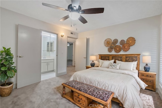 carpeted bedroom featuring ceiling fan, ensuite bath, and sink