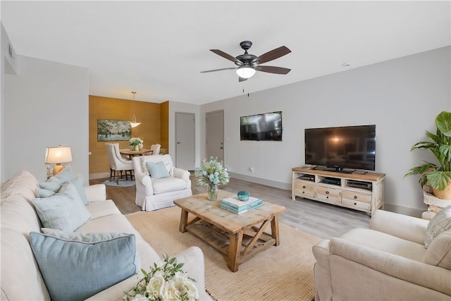 living room with ceiling fan and light wood-type flooring