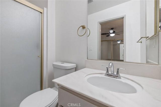 bathroom featuring vanity, an enclosed shower, ceiling fan, and toilet