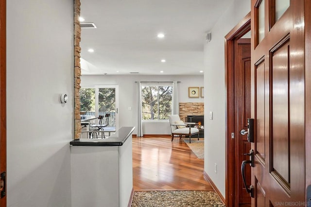 entrance foyer featuring light hardwood / wood-style floors and a stone fireplace