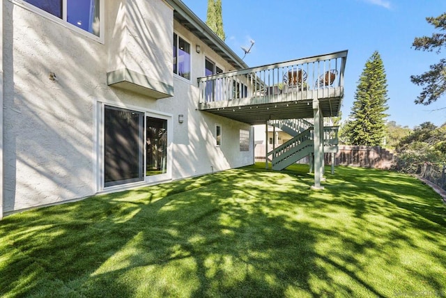 rear view of house featuring a lawn and a deck