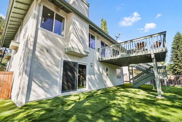 back of house with a deck and a lawn