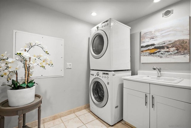 washroom with stacked washing maching and dryer, sink, light tile patterned floors, and cabinets