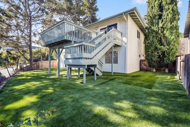 rear view of property featuring a wooden deck and a yard