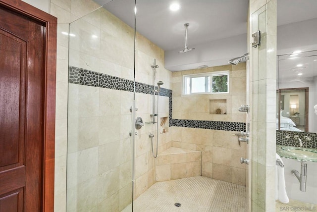 bathroom with a tile shower and sink