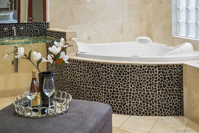 bathroom featuring sink, tiled tub, tile walls, and tile patterned flooring