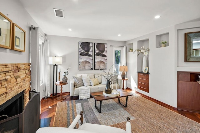 living room with dark hardwood / wood-style flooring and a fireplace