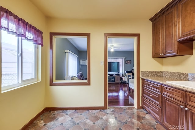 kitchen with ceiling fan and an AC wall unit