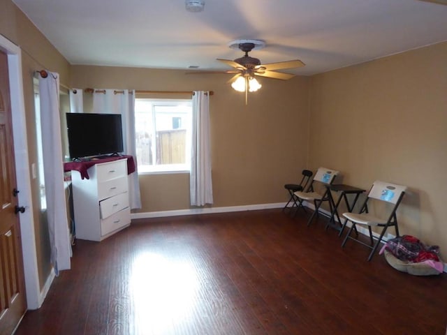 living area featuring ceiling fan and dark hardwood / wood-style flooring