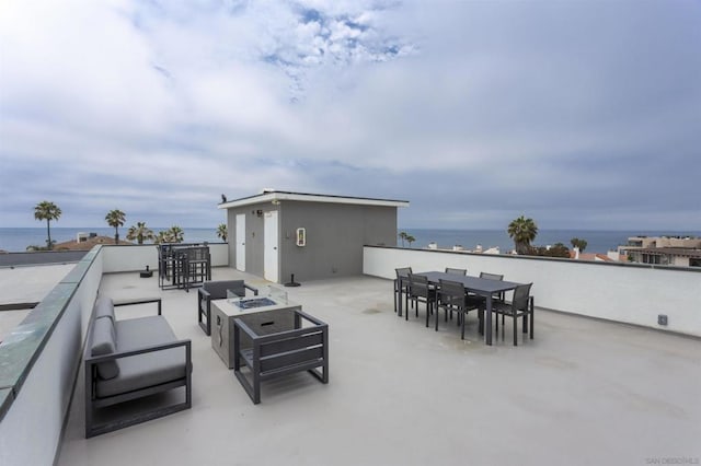 view of patio / terrace featuring a water view and an outdoor living space with a fire pit