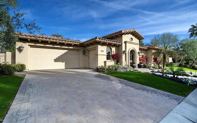 mediterranean / spanish-style home featuring a garage and a front yard