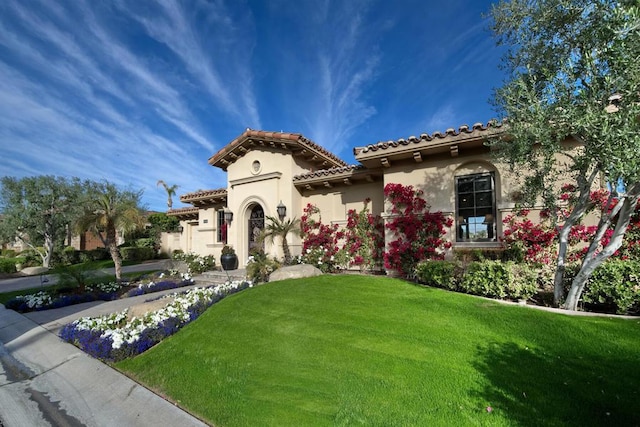 mediterranean / spanish-style home featuring a front yard