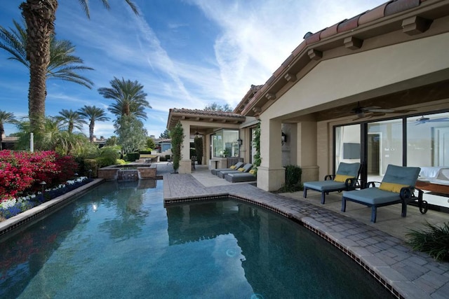 view of pool featuring ceiling fan, a patio area, and an in ground hot tub