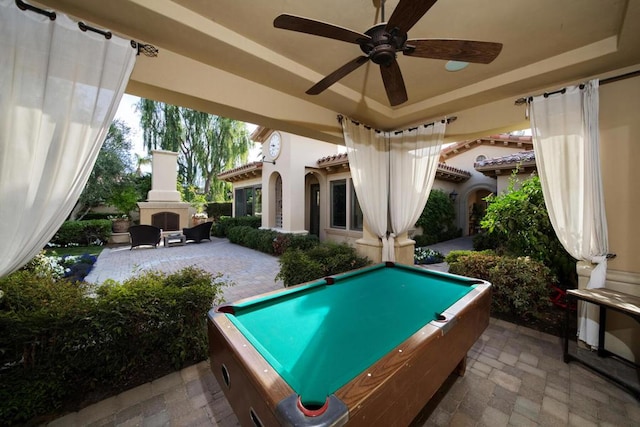 game room with ceiling fan, a tray ceiling, and billiards