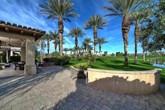 view of property's community featuring a patio area, a water view, and a yard