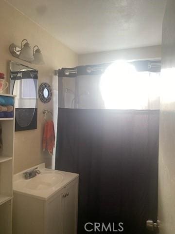 bathroom with walk in shower and vanity