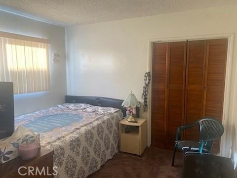 bedroom with a textured ceiling, a closet, and carpet flooring