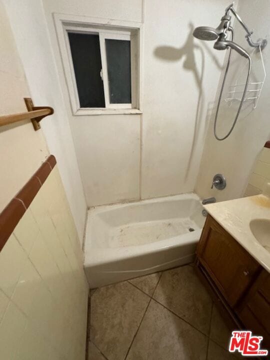 bathroom featuring tile patterned floors,  shower combination, and vanity