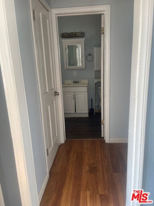 corridor featuring sink and dark hardwood / wood-style floors