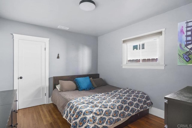 bedroom with dark hardwood / wood-style flooring