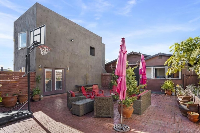 view of patio featuring french doors, fence, and a fire pit