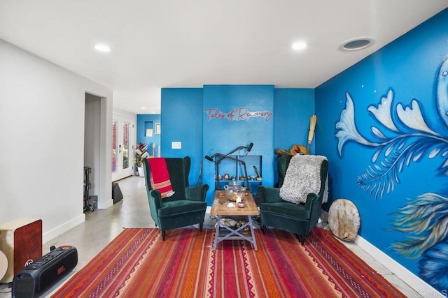 living area featuring concrete floors, baseboards, and recessed lighting