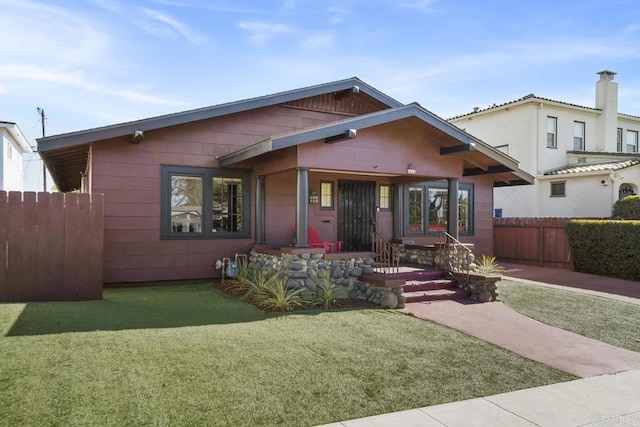 view of front facade featuring a front yard and fence