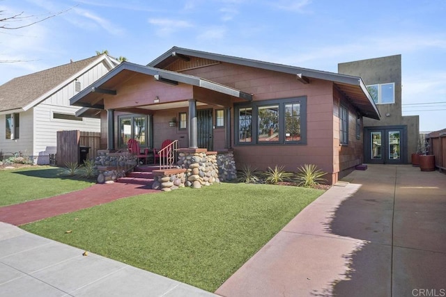 view of front facade featuring covered porch, a front lawn, and concrete driveway