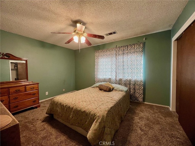 carpeted bedroom with ceiling fan, a closet, and a textured ceiling