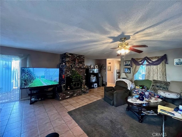 living room with ceiling fan, a wealth of natural light, tile patterned floors, and a textured ceiling