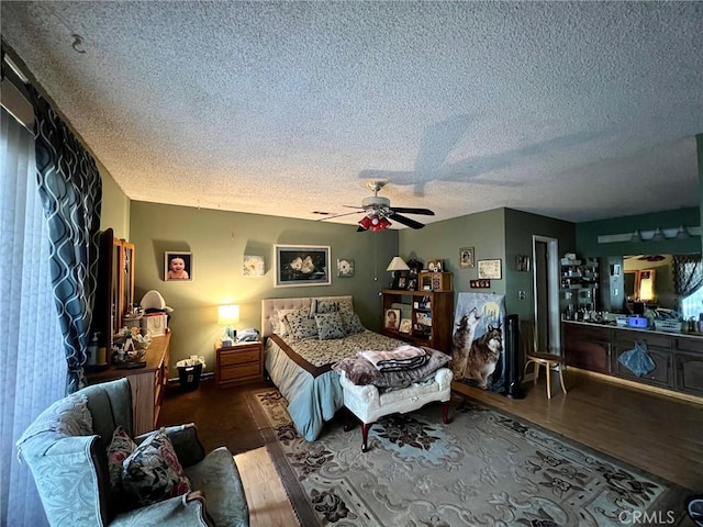 bedroom featuring ceiling fan, a textured ceiling, and dark hardwood / wood-style floors