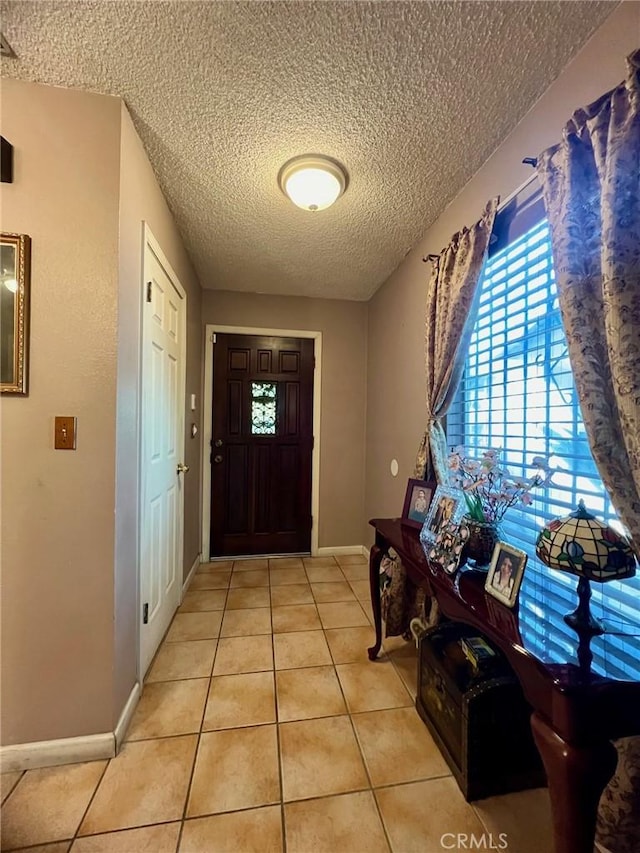 entryway with light tile patterned floors and a textured ceiling