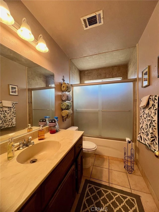 full bathroom with shower / bath combination with glass door, vanity, toilet, and tile patterned flooring