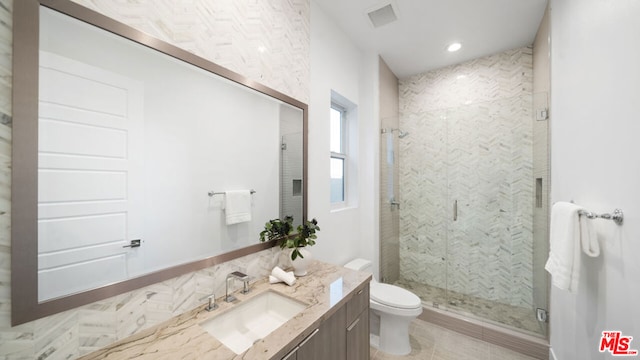 bathroom featuring an enclosed shower, vanity, and toilet