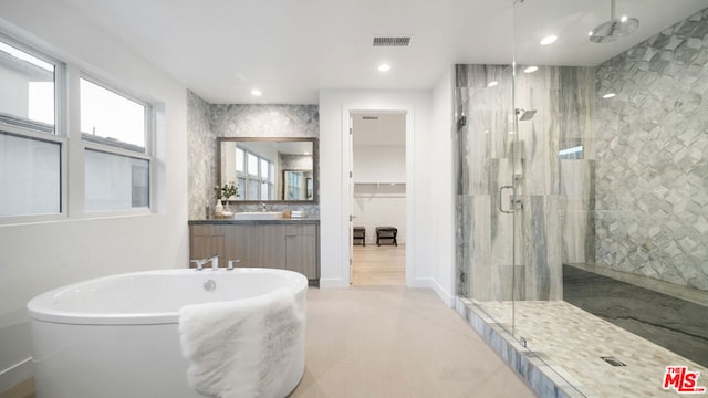 bathroom with separate shower and tub and vanity