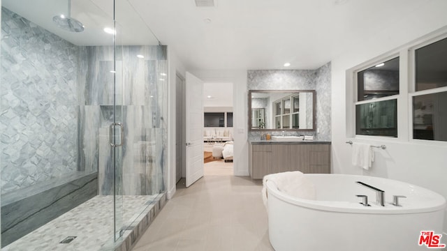 bathroom with tile patterned floors, separate shower and tub, and vanity